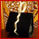 bolso en tela negra, exterior curvado, asa de una sola pieza en marfil liso